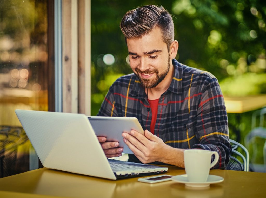 A man using laptop in a cafe.